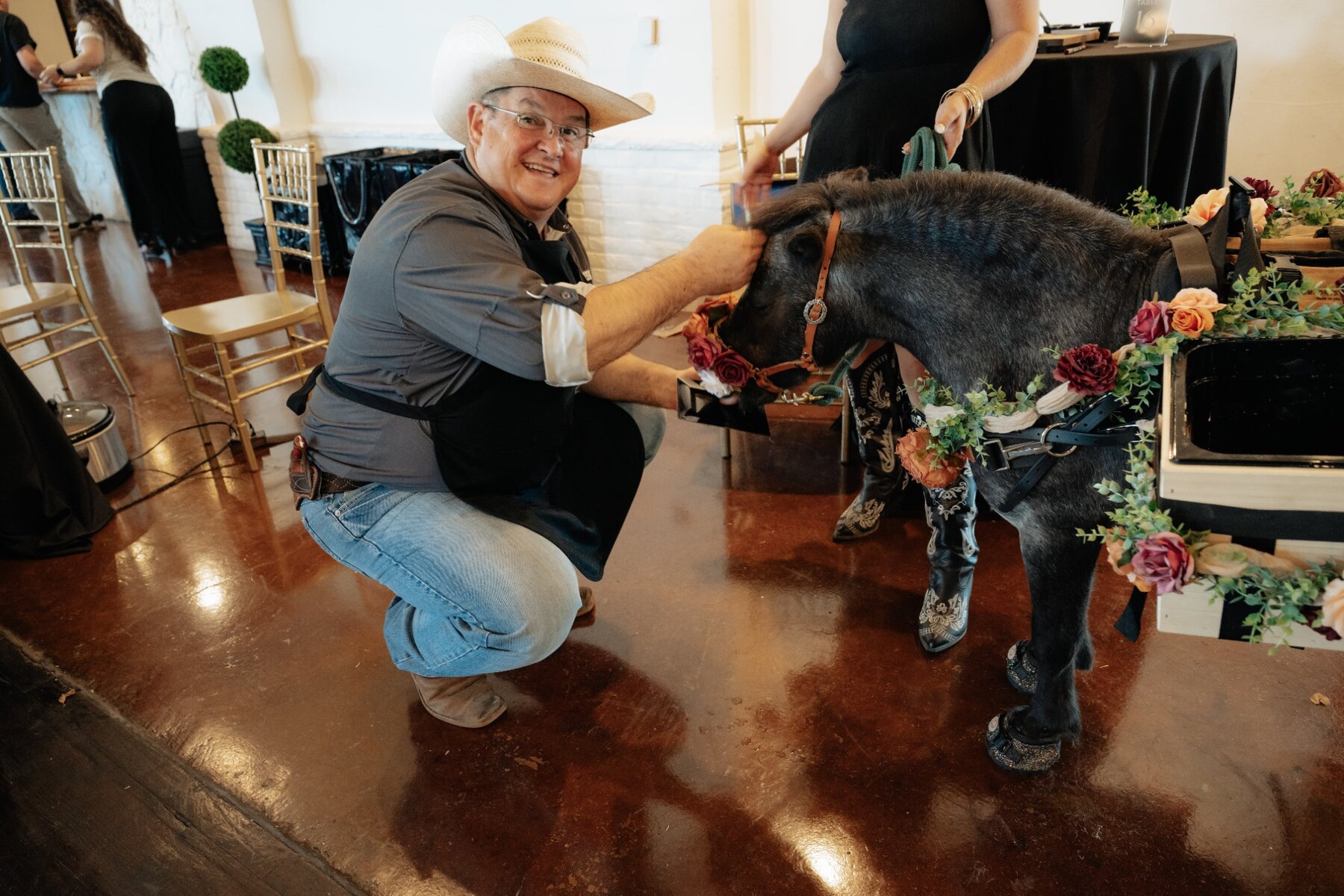 A wedding guest in a cowboy hat greeting Pickles the Party Pony